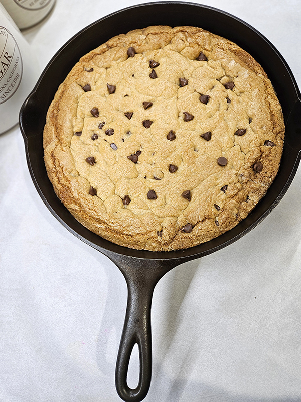 A large 12" cast iron skillet with the cookie baked inside
