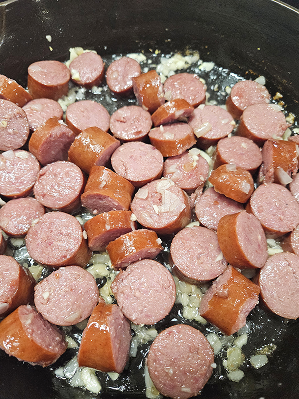 Cooking the sausage for Cheesy Bowtie Pasta and smoked sausage