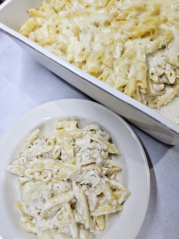 Plated and the dish of chicken alfredo penne bake
