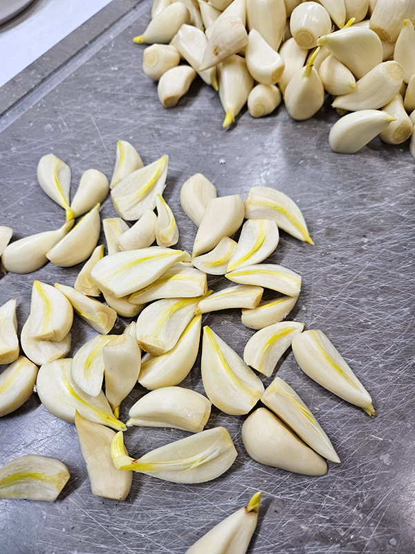 Garlic cloves cut in half showing the sprouts - freezing sprouted garlic