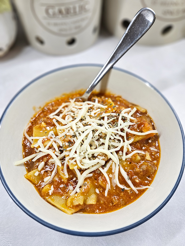 A bowl of dutch oven lasagna soup with cheese on top
