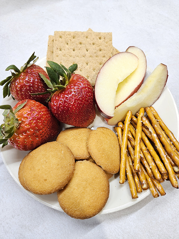 A plate of marshmallow strawberry fruit dip dippers.