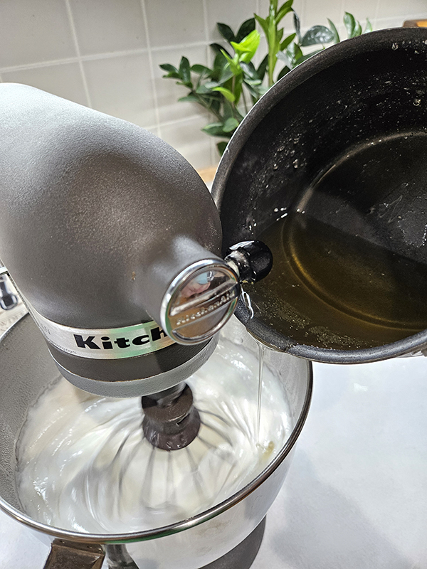 Adding in the melted sugar to the egg whites