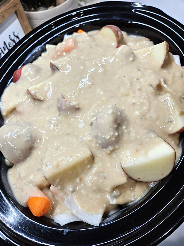 Soup poured over the ingredients in the slow cooker - creamy slow cooker pot roast