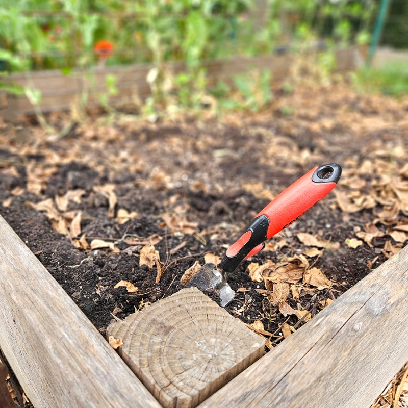 A raised garden bed with soil and fall leaves - Prepare Fall Garden Soil