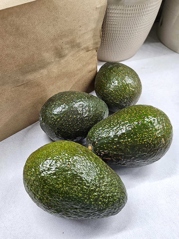 Four avocados near a paper bag - reduce food waste