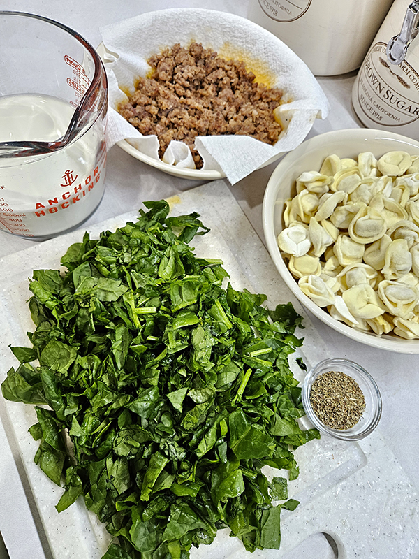 Spinach, cheese tortellini, seasonings, cooked sausage, and half and half