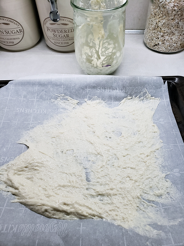 Sourdough starter spread on parchment paper