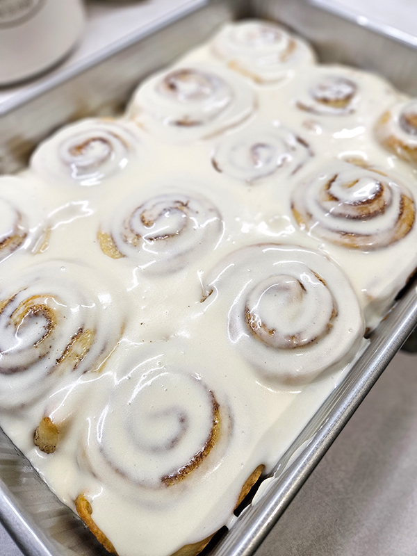 A sweet icing on freshly baked cinnamon rolls
