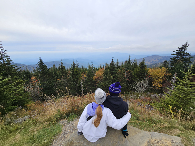 My kids sitting on a rock together looking out at the view from the parking lot at Clingmans Dome.